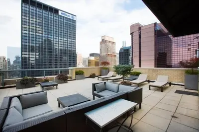 a rooftop patio with couches and tables and a city skyline at Sq 1BR w Great views Indoor pool NYC-29 in New York