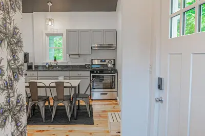 a kitchen with a table and a table and chairs at Campfire Cottage Fireplace, fire pit & no chores! in Kingston
