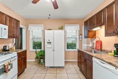 a kitchen with a white refrigerator in the middle at Cozy Retreat, Steps to Yale Bridgeport Hospital in Bridgeport
