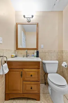 a bathroom with a toilet and a sink with a mirror at Bedroom near Yale Hospital/Bridgeport in Bridgeport