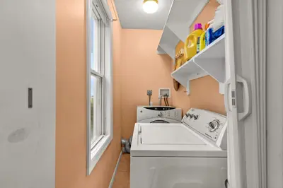 a laundry room with a washing machine and a window at Bridgeport Bliss Solo Haven Near Yale & Downtown in Bridgeport