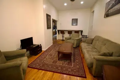 a living room with a couch and a table at Tuk Ahoy - Emerald Suite 2C with Shared Spaces in Brooklyn