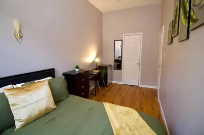 a bedroom with a green bed and a desk at Tuk Ahoy - Emerald Suite 3C with Shared Spaces in Brooklyn