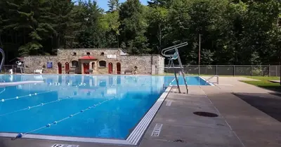 a large swimming pool with a building in the background at 3rd Base Apt 2 All Star Baseball Rentals in Oneonta