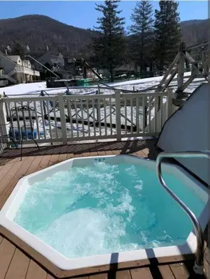 a hot tub on a deck with a chair at Must See Pirate Suite Ski On Off Jiminy - Mtn View Fully Redone Decor in Hancock