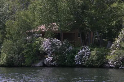 a house on the shore of a river with flowers at Captains Cabin - Cozy Cabin in Laurel Island in East Hampton