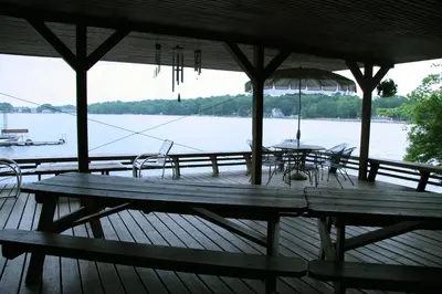 a wooden deck with a table and chairs and an umbrella at Captains Cabin - Cozy Cabin in Laurel Island in East Hampton