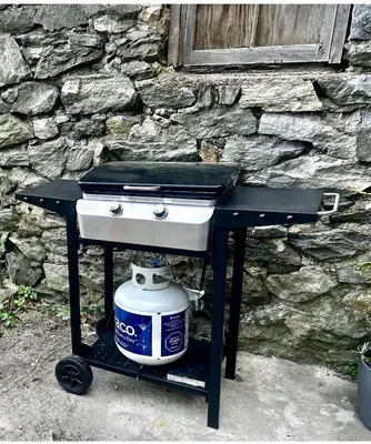 a grill with a pot on a table in front of a stone wall at 5-A Diamond in Yonkers in Yonkers