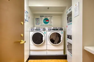 a laundry room with a washer and dryer at UWS 2BR w Elevator Gym DM Playroom Rooftop NYC-868 in New York