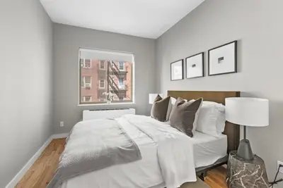 a bedroom with a large white bed and a window at Top Notch 2BR Suite Minutes to Central Park in New York