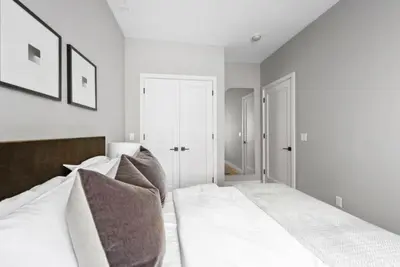 a bedroom with a bed with white sheets and pillows at Top Notch 2BR in Upper East Mins to Central Park in New York