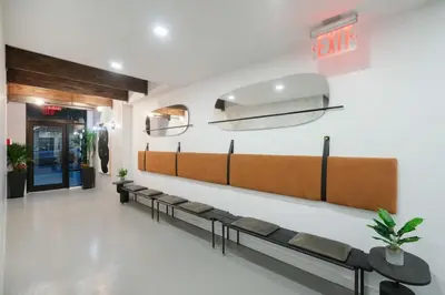a waiting room with a row of benches in a building at Top Notch 2BR in Upper East Mins to Central Park in New York