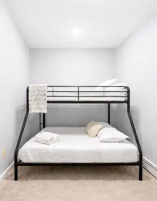 a black bunk bed in a white room at Cozy up with me! Longer stays! Free parking in Troy