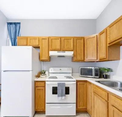 a kitchen with white appliances and wooden cabinets at Cozy up with me! Longer stays! Free parking in Troy