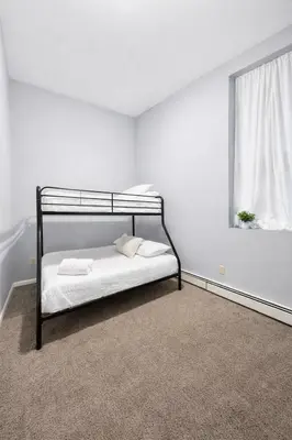 a bedroom with a black bunk bed with a window at Escape your everyday in your COZY HIDEAWAY Feel right at home Relax recharge & unwind in Troy
