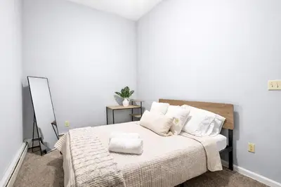 a bedroom with a bed with white sheets and pillows at Escape your everyday in your COZY HIDEAWAY Feel right at home Relax recharge & unwind in Troy