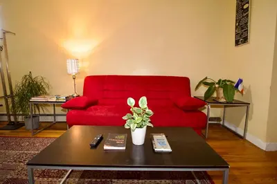 a living room with a red couch and a coffee table at Tuk Ahoy - Indigo Suite (3A) with Shared Spaces in Brooklyn