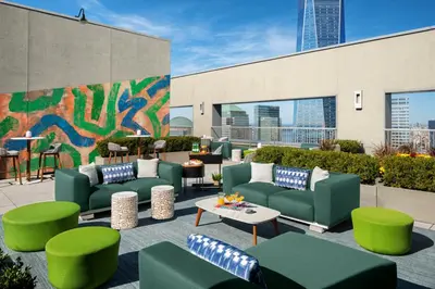 a patio with green couches and tables and a mural at Financial District 1br w WD gym elevator NYC-1360 in New York