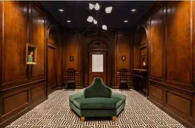 a green chair in a room with wooden walls at FiDi 1br w game room resident-only speakeasy NYC-1346 in New York