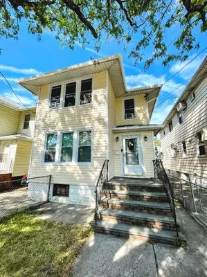 a yellow house with stairs in front of it at Entire Beautiful 1BR for You! [R] in Whitestone
