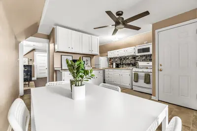 a kitchen with white cabinets and a white table and chairs at A walk to Yale Bridgeport Hospital in Bridgeport
