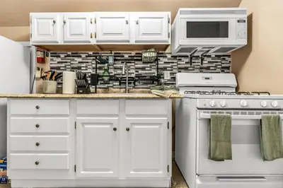 a kitchen with white cabinets and white appliances at A walk to Yale Bridgeport Hospital in Bridgeport