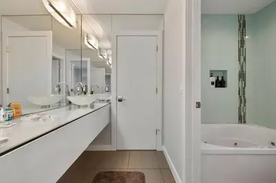a white bathroom with two sinks and a tub at Piermont Waterfront Villa! in Piermont