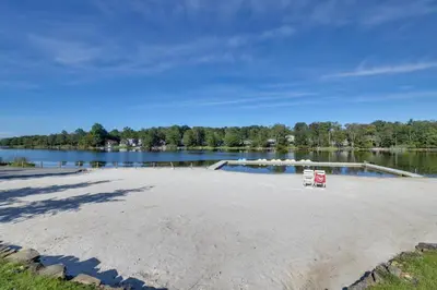 a sandy beach next to a body of water at Fire Pit, Pool and Beach Access Tobyhanna Home! in Tobyhanna