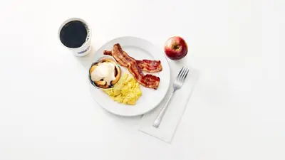 a plate of breakfast food with bacon and eggs at Holiday Inn Express Long Island City E - New York by IHG in Queens