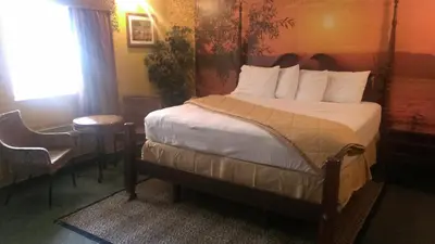 a bedroom with a bed and a table and a window at Naugatuck Motor Lodge in Naugatuck