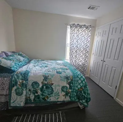 a bedroom with a bed with a comforter and a window at Room K Divine Villa and Resorts 5mins to EWR Airport and 4mins to Penn Station Newark, New York in Newark