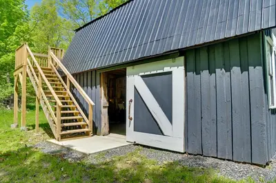 a barn with a large door and a set of stairs at Cozy Catskills Cabin - 12 Mi to Windham Mountain! in East Durham