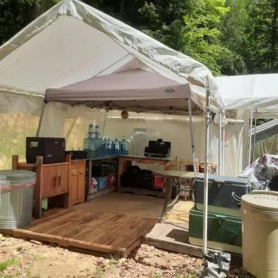 a white tent with a wooden deck under it at Tentrr Riverfront Ritz in Lake Luzerne