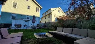 a backyard with a couch and a table and a house at Bella room near downtown Train I-95 & beaches in Stamford