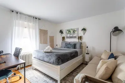 a bedroom with a bed and a couch at Stamford Bohemian by HarborPoint Downtown &Train in Stamford