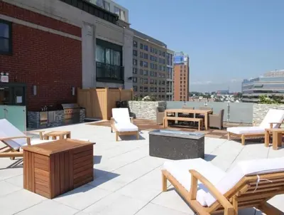 a patio with chairs and tables on top of a building at Luxurious 1BR Downtown Stamford in Stamford
