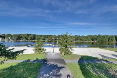 an empty park with a lake in the background at Wooded Tobyhanna Home with Fire Pit and Lake Access! in Tobyhanna