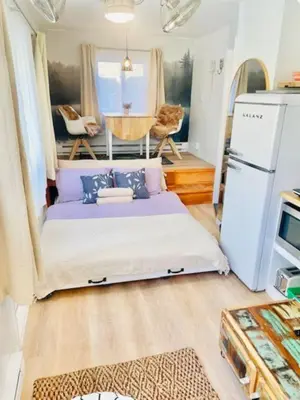 a bed in the middle of a tiny house at Catskill Cabin Little Owl Apt 1 in Shandaken