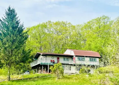 a large house in the middle of a field at Catskill Cabin Apres Ski in Shandaken