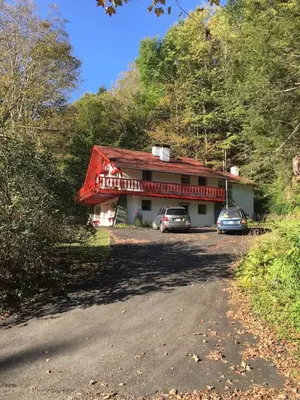 a house with two cars parked in front of it at Alpine Four Season Lodge Shandaken NY sleeps 18 in Shandaken