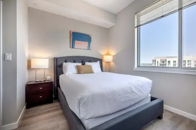 a bedroom with a large bed and a window at Trendy Apt On Harbor with Gym in Stamford