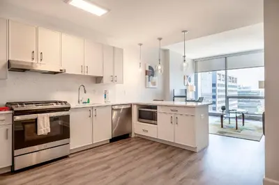 a kitchen with white cabinets and a large window at Private Luxury Apt with Gym in Stamford