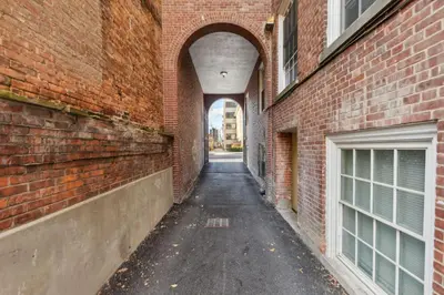 an alley between two brick buildings with an archway at Washington Lofts 109 Spacious 1 Bedroom 1 Bath in Albany