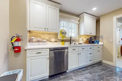 a kitchen with white cabinets and a stainless steel dishwasher at Work, Play and Stay! Apt Near Holyoke Medical Center in Holyoke