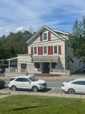 two cars parked in a parking lot in front of a house at The Innwoods - Studio Apartment 2 in Tannersville