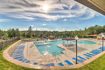 a pool at a resort with blue chairs at 1 floor, Pocono Pond house with Game Room in Tobyhanna