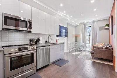 a kitchen with stainless steel appliances and a living room at SWJ 4 - 25 Min to Times Sq Save on 2Day Stays in New York