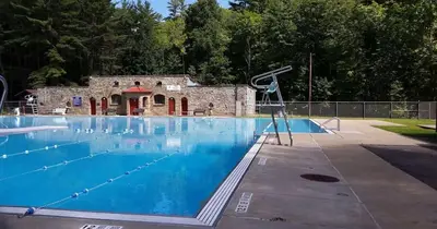 a large swimming pool with a building in the background at Pitcher's Paradise Apt 3 All Star Baseball Rentals in Oneonta