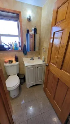 a bathroom with a toilet and a sink at Nice rooms Woodside in Queens