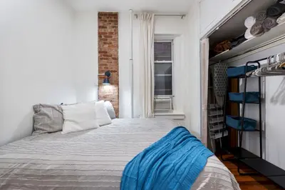 a bedroom with a bed and a window at Spacious 2BR on the Upper East Side Steps from Central Park in New York